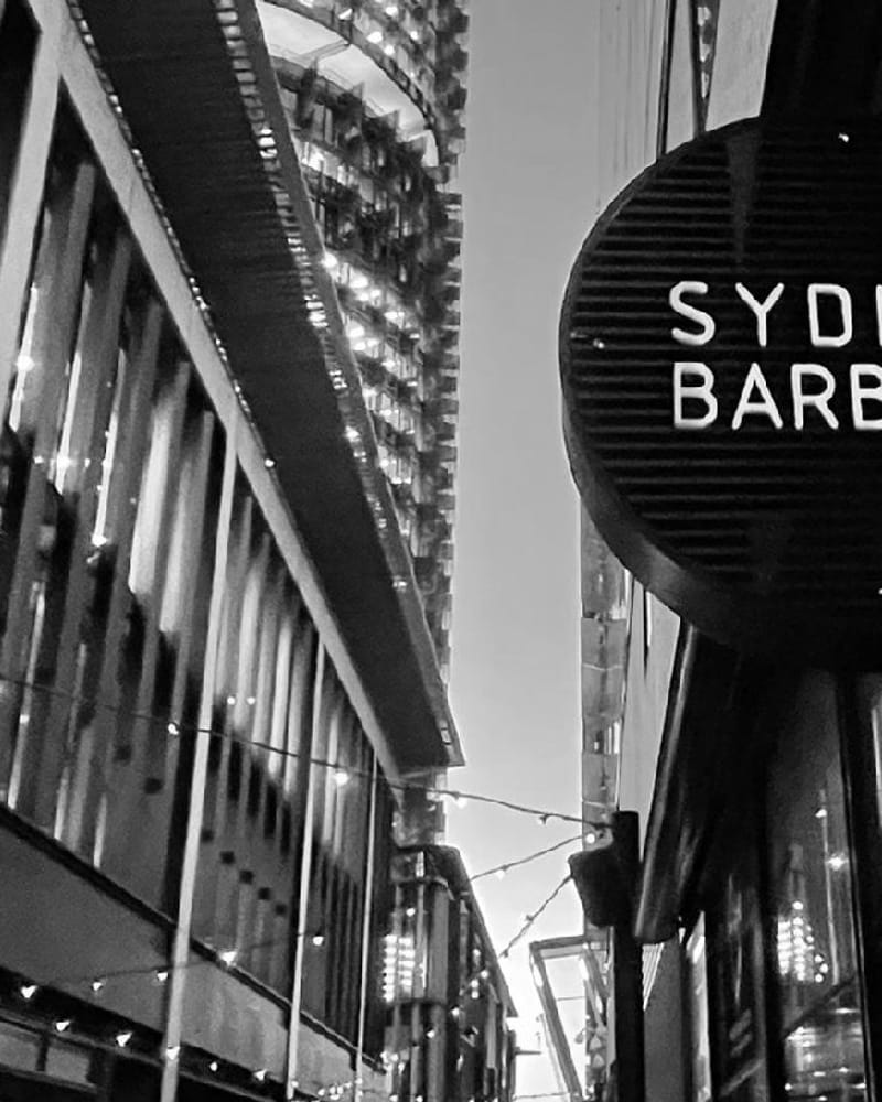Exterior view of barber shop sign on urban street