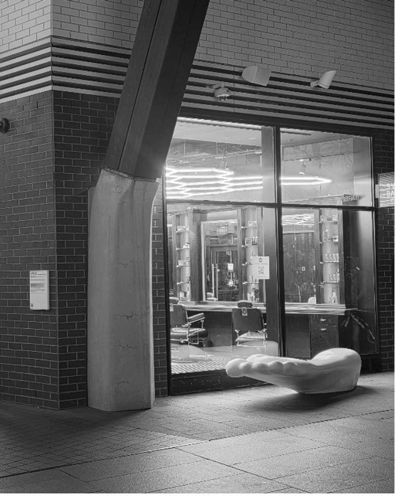 Exterior view of barber shop storefront with glass windows and barber chairs visible inside